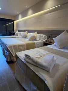 a group of three beds in a hotel room at Andes Xtreme Hotel Boutique in Tinogasta +4 photos