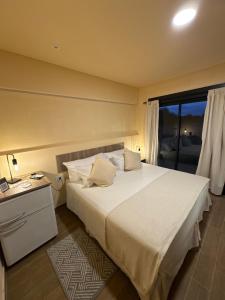 a bedroom with a large white bed and a window at Andes Xtreme Hotel Boutique in Tinogasta
