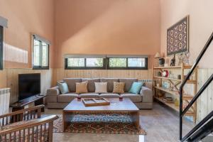a living room with a couch and a coffee table at Maison Jwar - Charming Caravan Experience - Unique Summer Getaway in Jiwār al Ḩawz