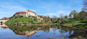 a castle on an island in the middle of a river at La Villonnière in Parnac