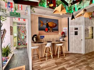 a room with a kitchen with stools and a counter at HOSTEL Pepper-Gold -STEP-FREE ENTRANCE -car- free Space-no nois-3 minutes from Port -BED ROOMS 8 GUEST 55 M2 AND 8 GUEST 65 M2 in Alicante