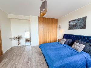 a bedroom with a blue bed in a room at Cozy Apartment Kaija in Liepāja