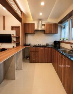 a kitchen with wooden cabinets and a sink at Mirage 8D Inn in Vythiri