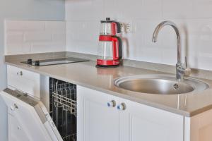 a kitchen counter with a sink and a red appliance at Mavi Kıyı Suites in Kaş +68 photos