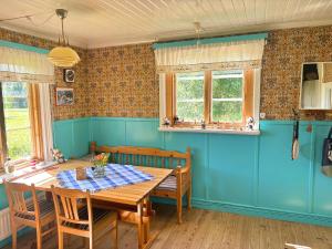 a dining room with a wooden table and blue walls at Hus Hammerstrand in Hammarstrand
