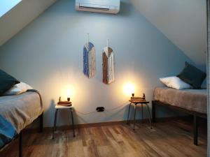 a room with two beds and two lights on the wall at Le fenil du Grand Dormeur - Chambres d'hôtes in Bischoffsheim