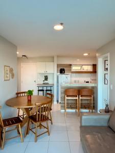 a kitchen and living room with a table and chairs at Mandai Apartamentos in Cabo Frio
