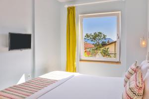 a bedroom with a bed and a window at Mavi Kıyı Suites in Kaş