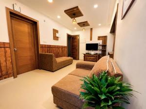 a living room with a couch and a tv at Mirage 8D Inn in Vythiri