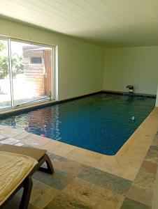 a swimming pool in a room with a large window at Iris in Valras-Plage
