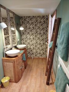 a bathroom with two sinks and a wall at Le fenil du Grand Dormeur - Chambres d'hôtes in Bischoffsheim