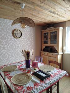 a table with plates and a clock on a wall at Le fenil du Grand Dormeur - Chambres d'hôtes in Bischoffsheim +20 photos