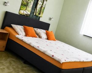 a bed with orange and white pillows on it at Siebers-Ferienwohnung in Saupsdorf