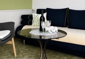 a table with a bottle of wine and glasses on a couch at Siebers-Ferienwohnung in Saupsdorf