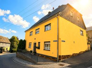 a yellow house on the side of a street at Siebers-Ferienwohnung in Saupsdorf