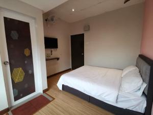 a bedroom with a white bed and a large window at Moon Hotel BRINCHANG Town in Brinchang