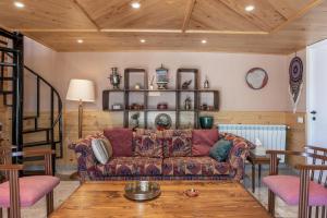 a living room with a couch and a table at Maison Jwar - Charming Caravan Experience - Unique Summer Getaway in Jiwār al Ḩawz