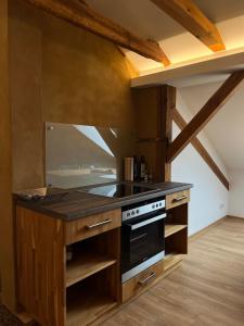 a kitchen with wooden cabinets and a stove top oven at Studio-Style Apartment in Spreenhagen +19 photos