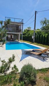 a swimming pool in front of a house at VRHouse Vorbis River House in Ada Skeljanska