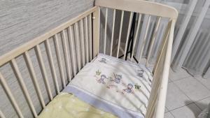 a crib with a blanket on top of it at Gîte à 15km PUY duFOU 5pers 3chambres in Pouzauges