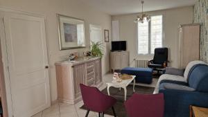 a living room with a blue couch and purple chairs at Gîte à 15km PUY duFOU 5pers 3chambres in Pouzauges