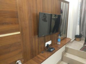 a bathroom with a television on a wooden wall at AA Grand in Hyderabad
