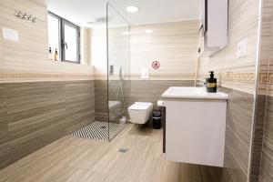 a bathroom with a toilet and a sink and a shower at Villa Reve de Tirana in Tirana