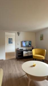a living room with a couch and a table and a tv at Ferienwohnung Alte Metzgerei in Mesenich