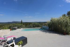a swimming pool with a table and chairs on a patio at Chez Sylvain in Carcès