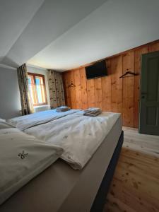 a large bed in a room with wooden walls at Das Kothberg in Lunz am See
