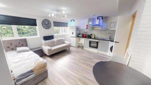 a room with a bed and a couch and a kitchen at The Lofton A Loft Above the Rest in Headingley