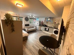 a living room with a table and a couch and a kitchen at The Lofton A Loft Above the Rest in Headingley