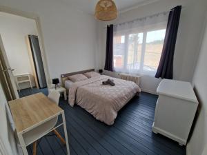 a bedroom with a bed and a table and a window at Spacieux duplex familial proche Dunkerque et plage in Coudekerque-Branche