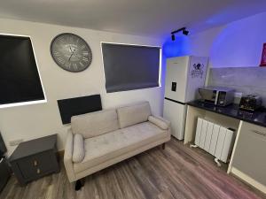 a living room with a couch and a clock on the wall at The Lofton A Loft Above the Rest in Headingley +25 photos