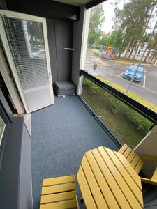 a room with a window with a yellow chair and a door at Moderni yksiö, omalla autopaikalla in Joensuu