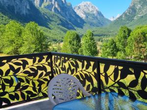 a balcony with a table and a chair and mountains at Nana Time Guesthouse in Vusanje