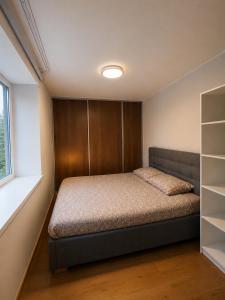 a bedroom with a bed and a book shelf at AM Apartment in Tallinn