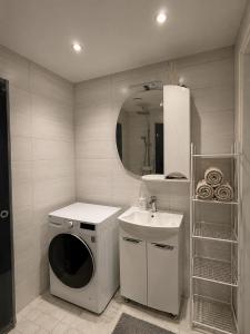 a bathroom with a washing machine and a sink at AM Apartment in Tallinn