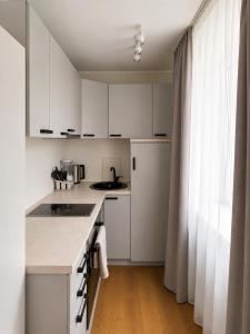 a kitchen with white cabinets and a counter top at AM Apartment in Tallinn