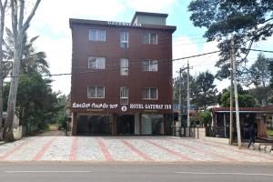 a tall brick building on the side of a street at Hotel Gateway Inn in Kushālnagar +5 photos