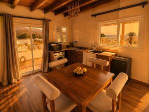 a kitchen with a wooden table and chairs and a kitchen with a balcony at Isis Dahab in Dahab