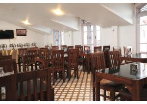 a dining room with wooden tables and chairs at hotel the kannaz in Srinagar