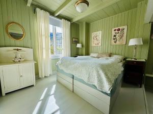 a green bedroom with a bed and a window at Kramsjø Gjestgiveri in Herand +9 photos