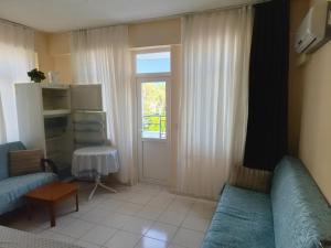 a living room with two blue couches and a window at ÖZNUR APART OTEL in Side