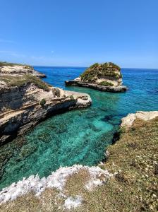 an island in the ocean with blue water at Masseria Santa Laria in Borgagne