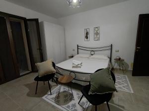 a bedroom with a bed with two chairs and a table at Masseria Santa Laria in Borgagne