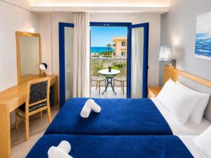 a hotel room with a bed and a desk and a table at Sergiani Garden Hotel Apartments in Stalís +67 photos