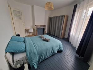 a bedroom with a teddy bear laying on a bed at Spacieux duplex familial proche Dunkerque et plage in Coudekerque-Branche