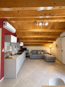 a kitchen and a living room with a couch at Casa Vacanze Guccini in Porticello