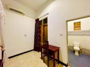 a room with a toilet and a table and a mirror at Soul Breeze in Arugam Bay